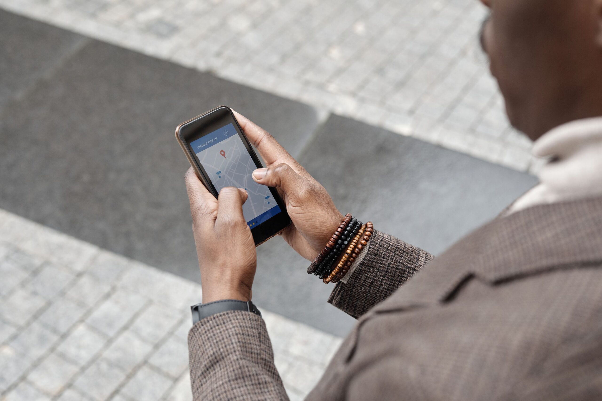 Osoba w garniturze korzystająca z aplikacji mobilnej na smartfonie